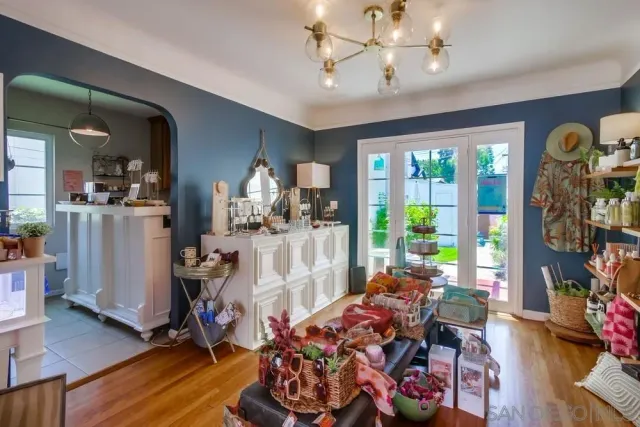 a room with lots of white furniture and a wooden floor