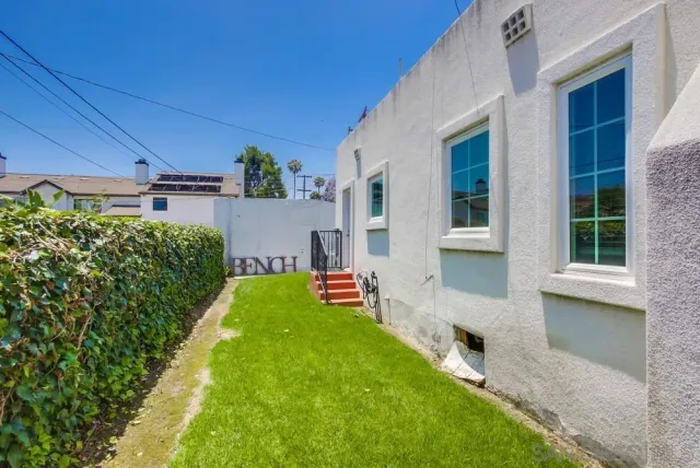 a front view of a house with a yard and potted plants