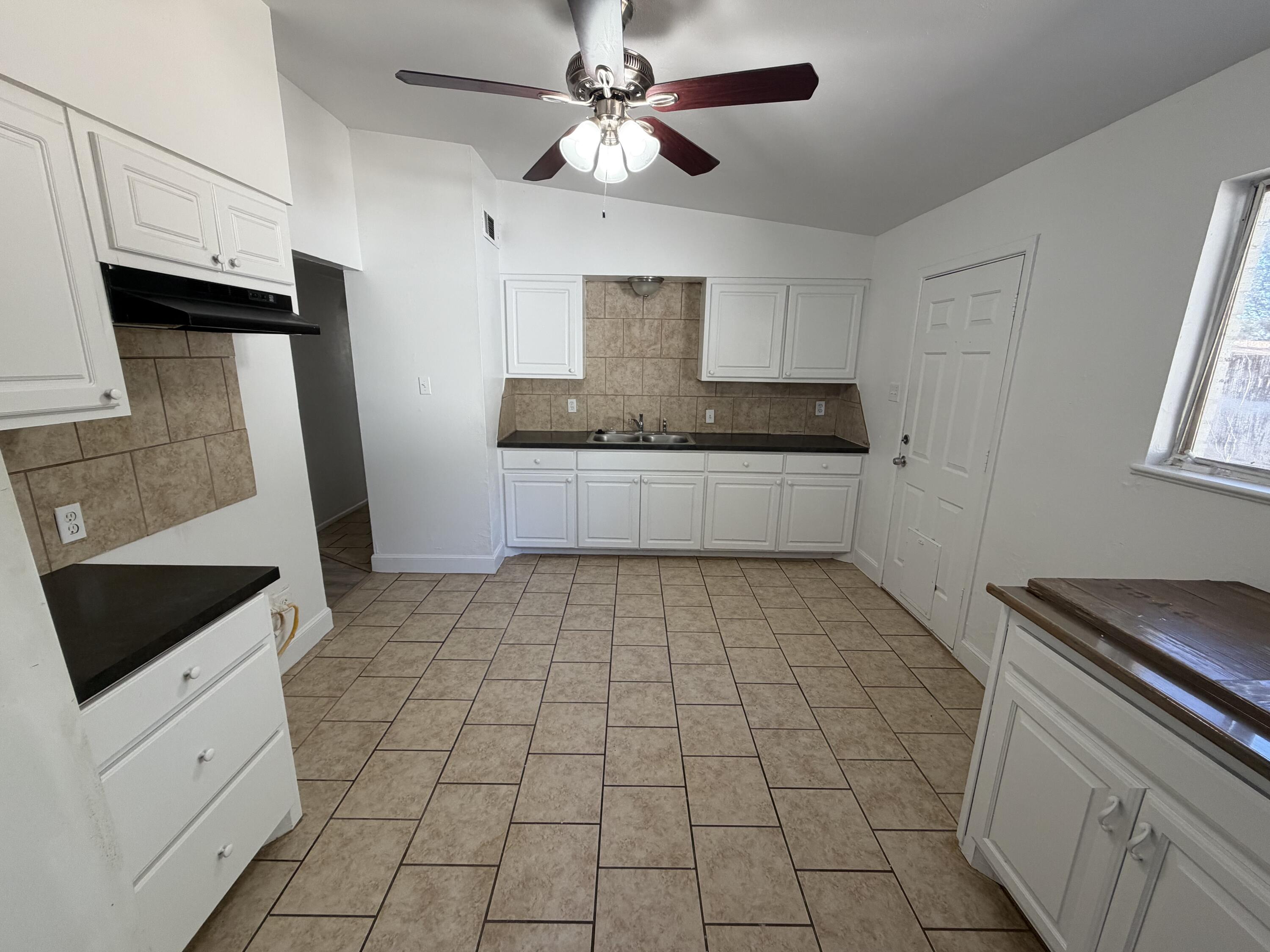 6004 Peoria Avenue Lubbock, TX 79413 - Photo 5 of 7 a kitchen with stainless steel appliances a sink a stove a microwave and cabinets