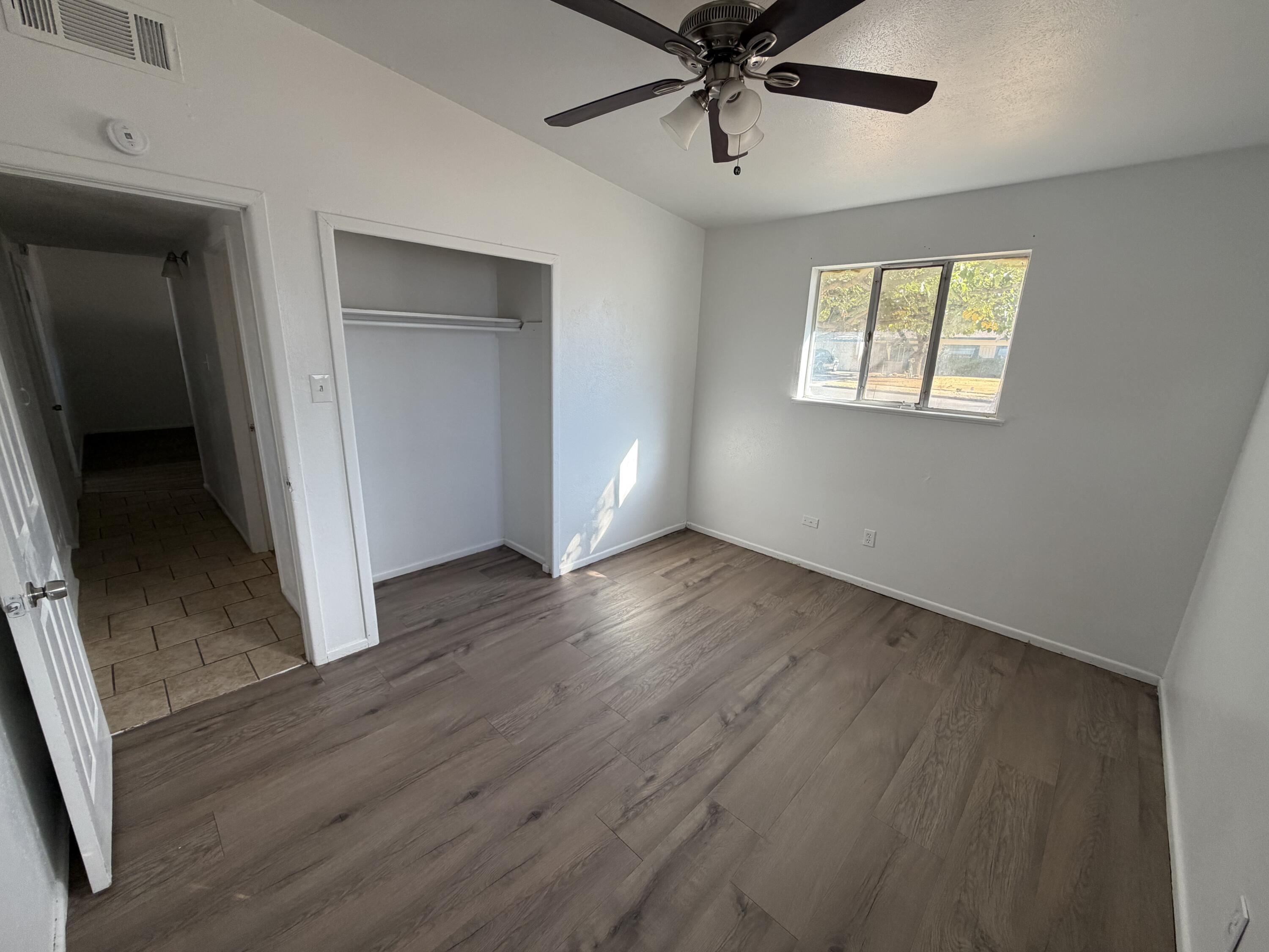 6004 Peoria Avenue Lubbock, TX 79413 - Photo 7 of 7 a view of an empty room with a window and wooden floor