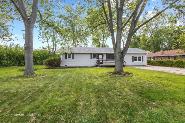 a front view of a house with yard and green space