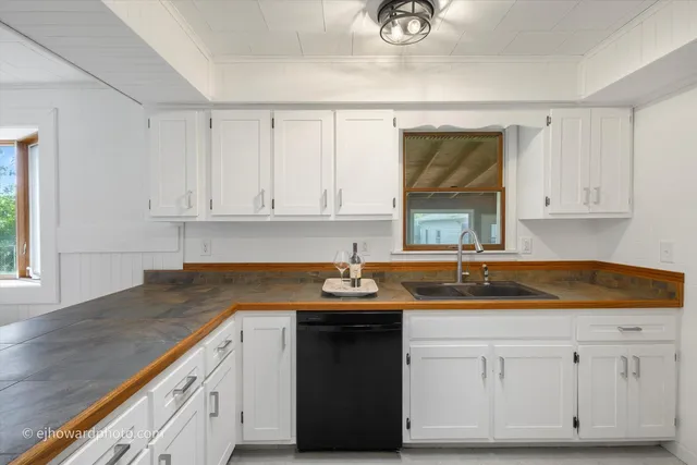 a kitchen with granite countertop white cabinets and a sink