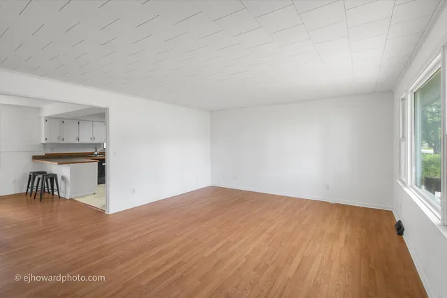 a view of workspace room with wooden floor and a window