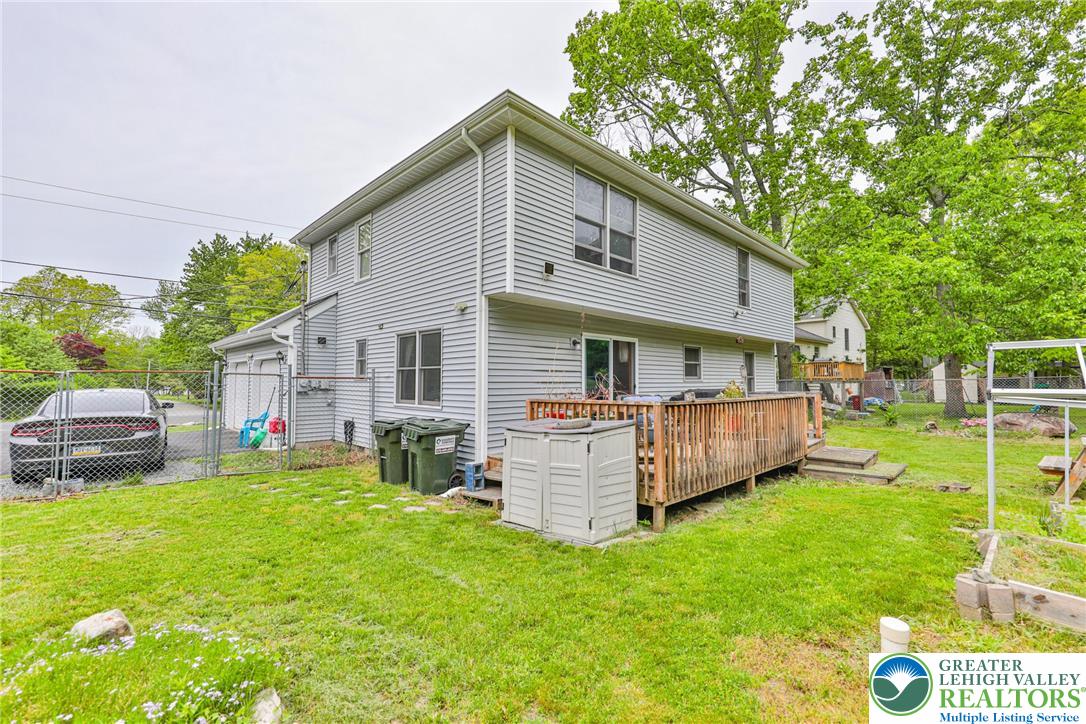 4608 Pine Ridge Drive West Bushkill, PA 18324 - Photo 49 of 62 A spacious backyard with mature trees, a wooden deck, and a fenced-in driveway offers ample outdoor living.