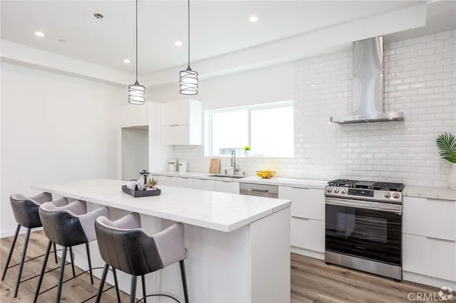 a kitchen with a stove a table and chairs in it