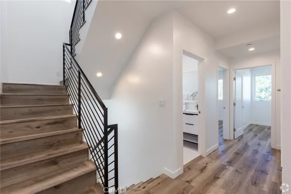 a view of a hallway with wooden floor and staircase