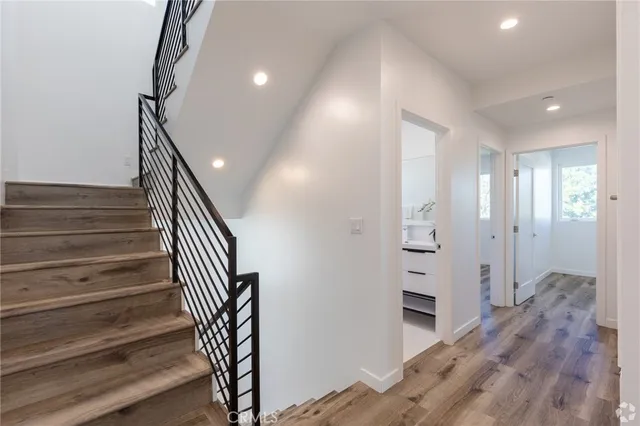 a view of a hallway with wooden floor and staircase