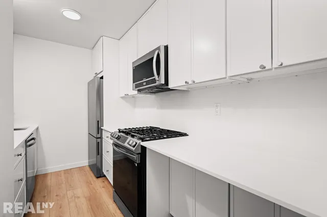 a kitchen with granite countertop a stove and a microwave