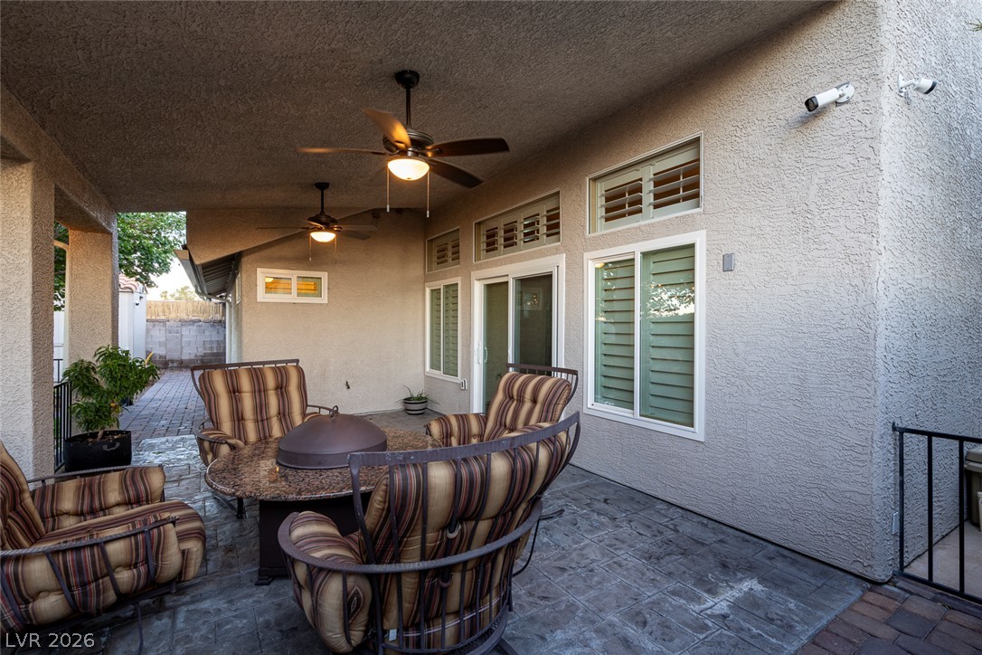 818 Manor Shores Road Henderson, NV 89002 - Photo 30 of 35 A spacious covered patio invites relaxation, featuring ceiling fans and ample seating for outdoor gatherings.
