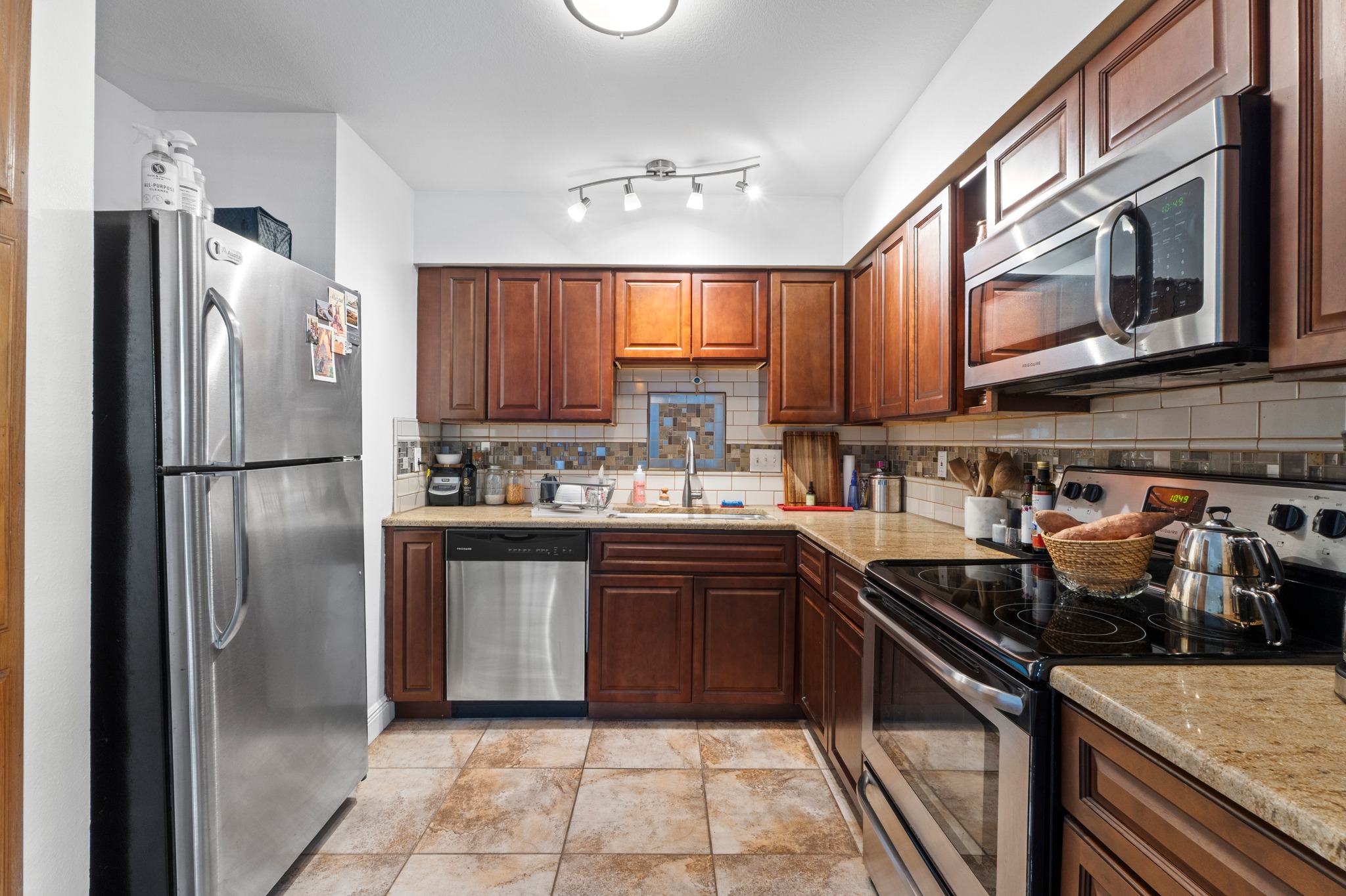 1750 Timber Ridge Road, Unit 102 Austin, TX 78741 - Photo 11 of 24 a kitchen with stainless steel appliances granite countertop a refrigerator a sink a stove and cabinets