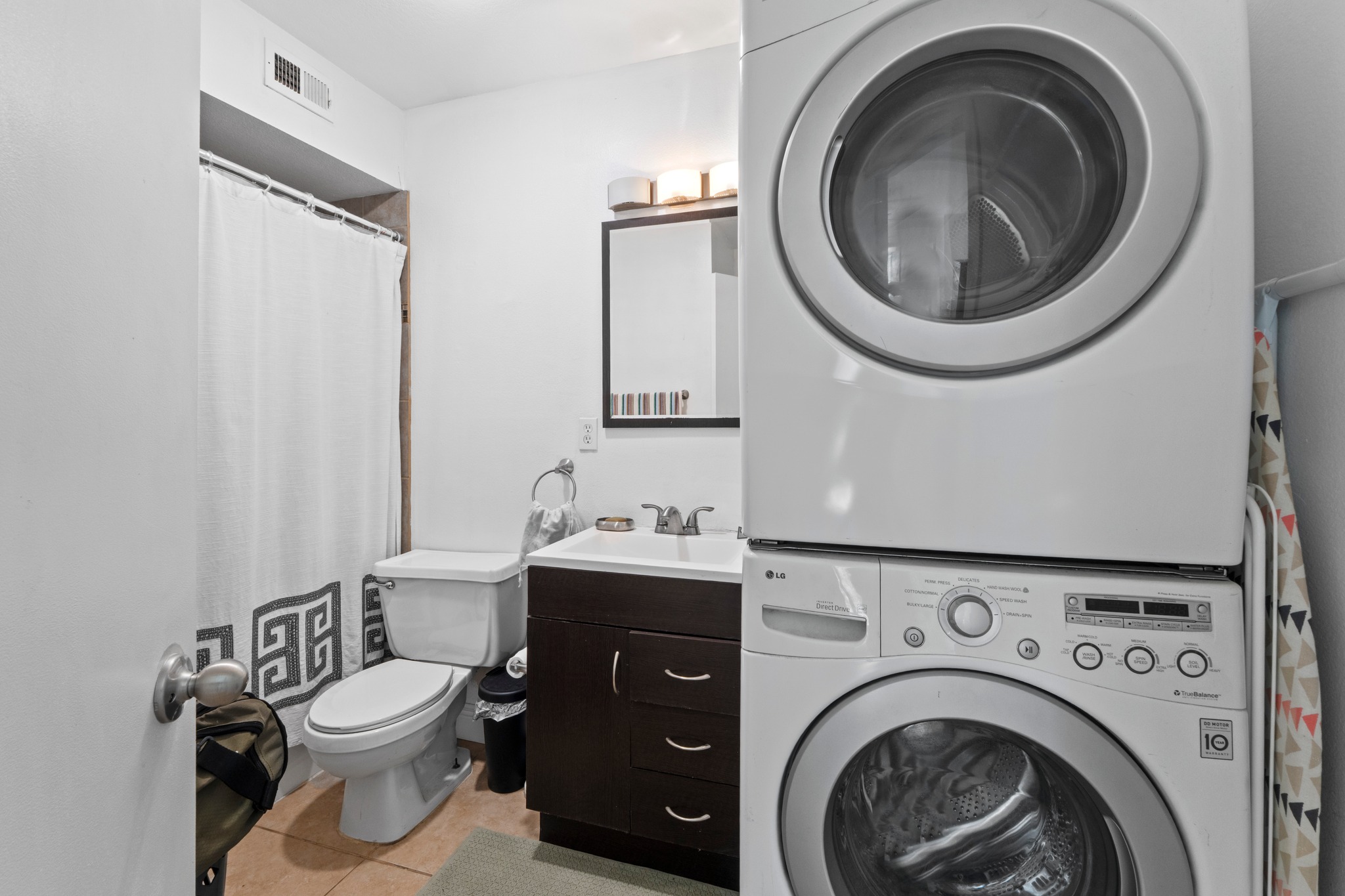 1750 Timber Ridge Road, Unit 102 Austin, TX 78741 - Photo 18 of 24 a bathroom with a toilet a sink and a mirror