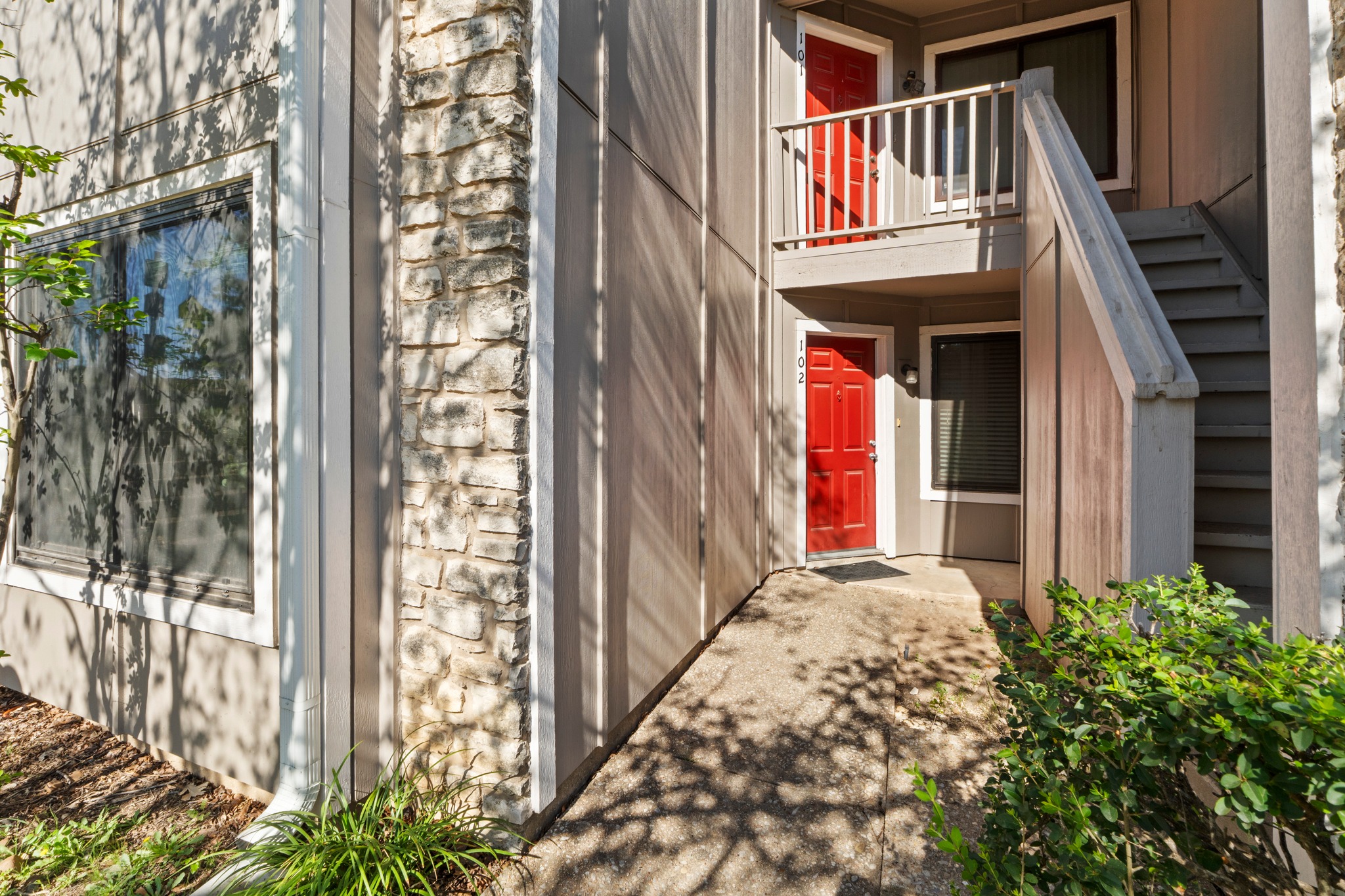 1750 Timber Ridge Road, Unit 102 Austin, TX 78741 - Photo 23 of 24 a view of a brick house with many windows and flower plants