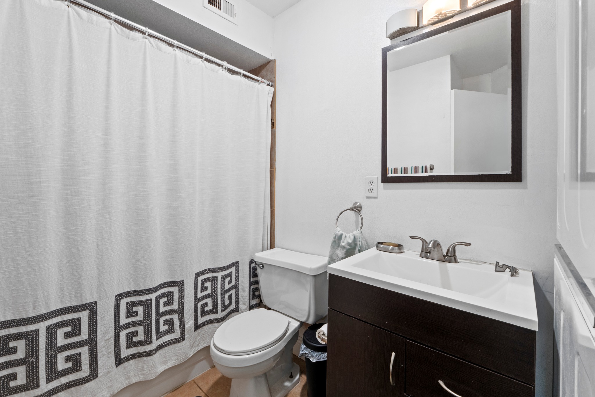 1750 Timber Ridge Road, Unit 102 Austin, TX 78741 - Photo 7 of 24 a bathroom with a toilet a sink and a mirror