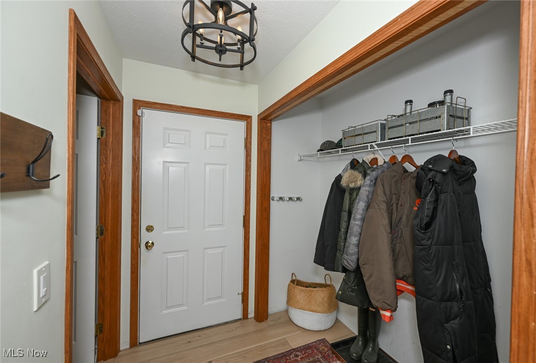 4845 State Road Medina, OH 44256 - Photo 22 of 47 Mudroom with a chandelier, light wood-type flooring, and a textured ceiling