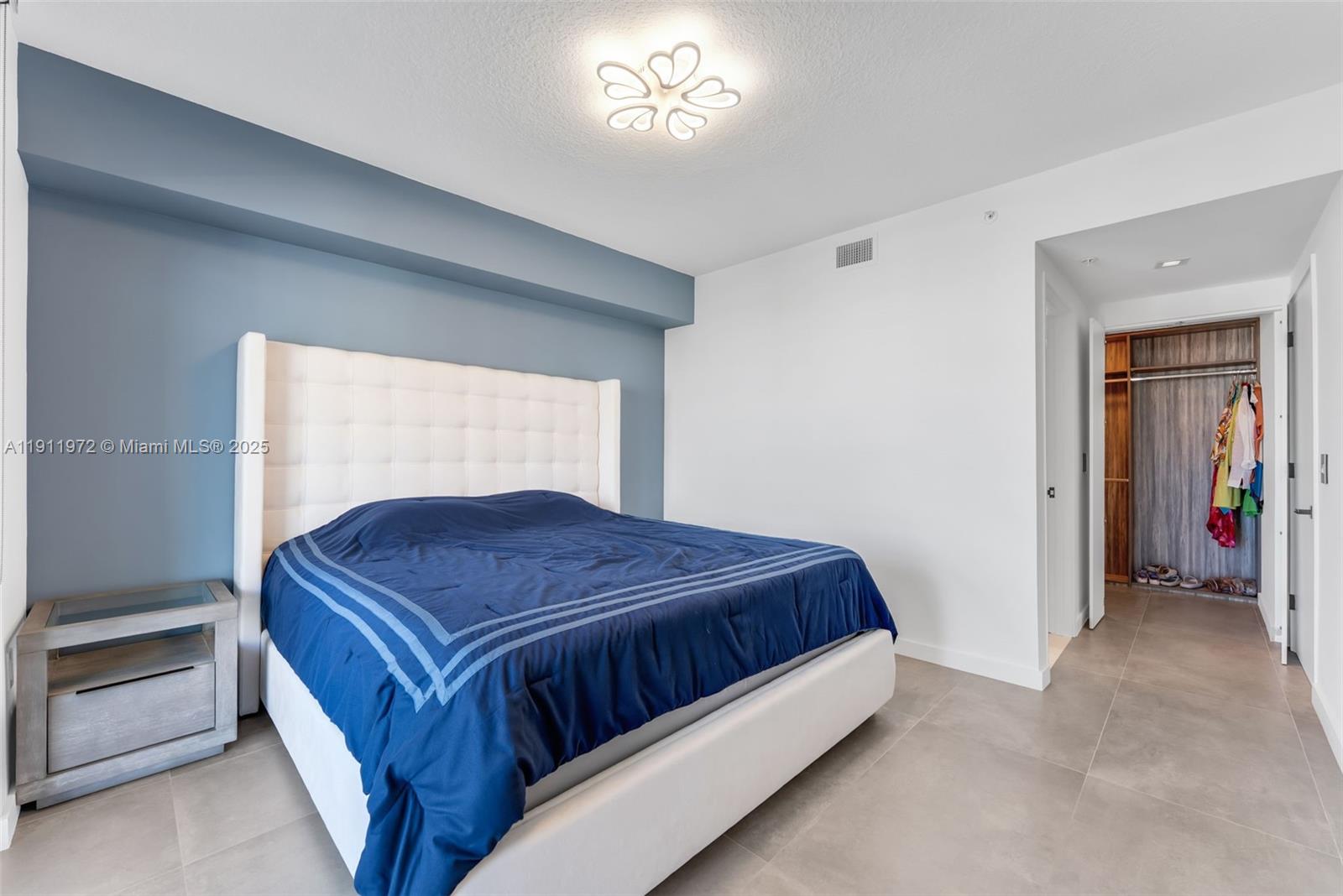 300 Sunny Isles Boulevard, Unit 4905 Sunny Isles Beach, FL 33160 - Photo 16 of 35 a bedroom with a bed and a chandelier