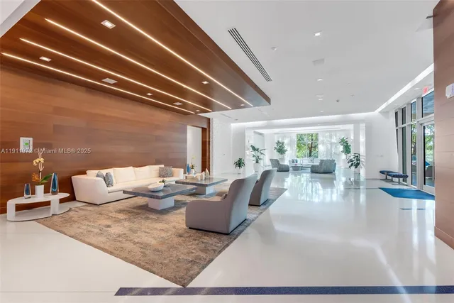a living room with fireplace furniture and a view of kitchen