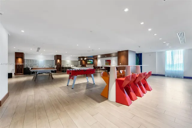 a living room with stainless steel appliances kitchen island furniture and a wooden floor