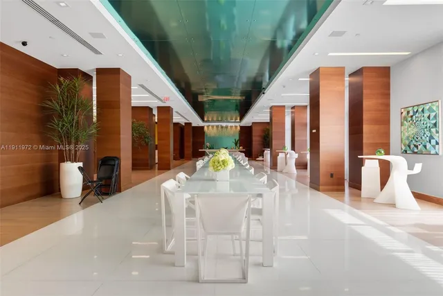 a dining room with furniture and a floor to ceiling window