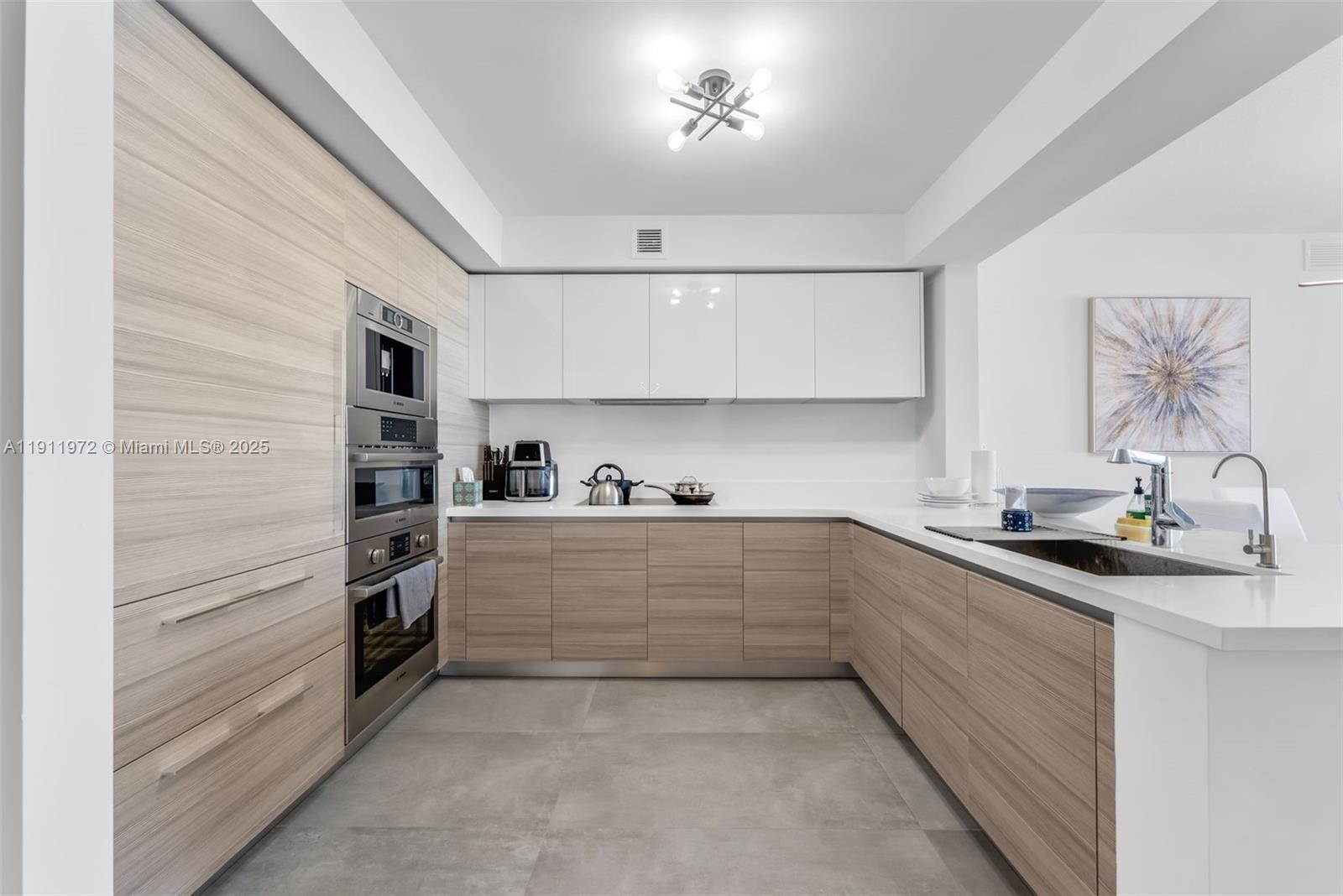 300 Sunny Isles Boulevard, Unit 4905 Sunny Isles Beach, FL 33160 - Photo 6 of 35 a kitchen with granite countertop a sink and cabinets