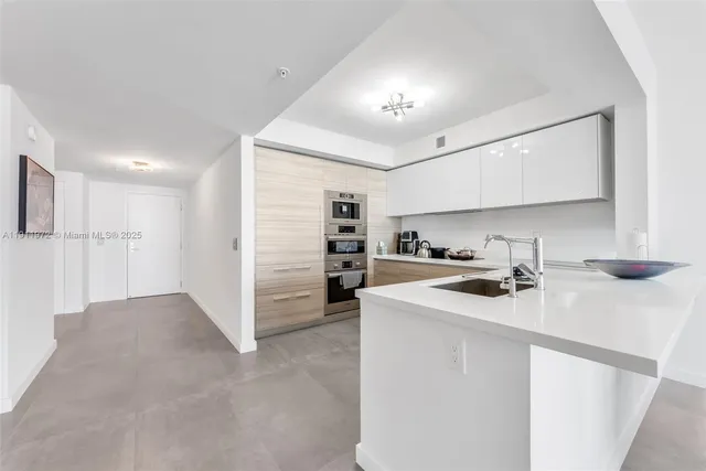 a kitchen with refrigerator and cabinets