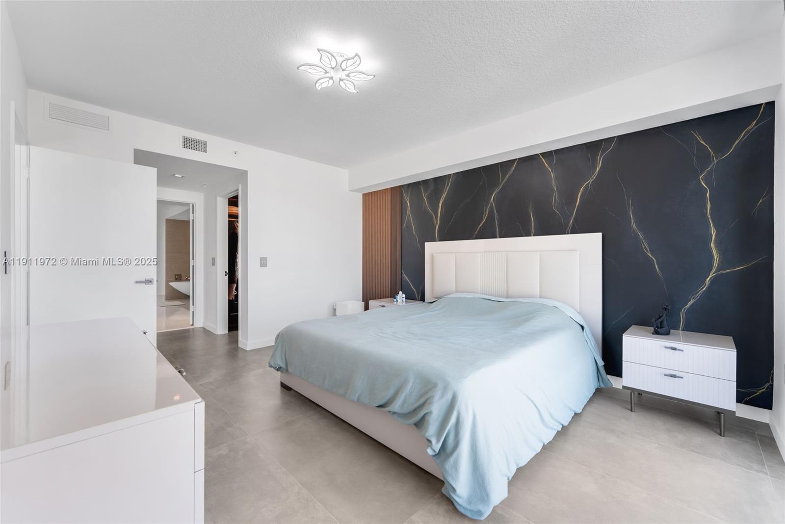 300 Sunny Isles Boulevard, Unit 4905 Sunny Isles Beach, FL 33160 - Photo 10 of 35 a bedroom with a bed and a night stand