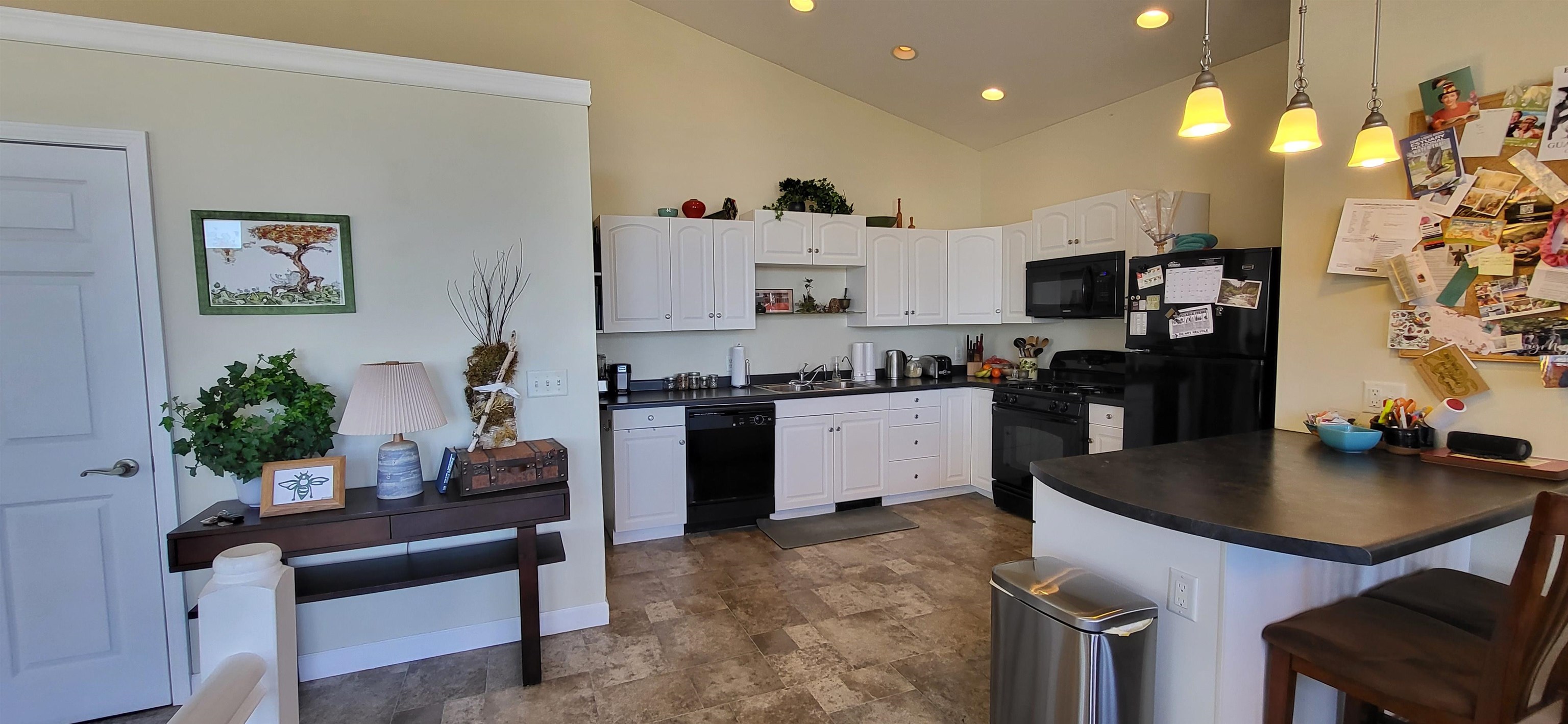 908 East Skyline Parkway Duluth, MN 55805 - Photo 13 of 40 Kitchen featuring black appliances, dark countertops, high vaulted ceiling, stone finish floors, and a sink
