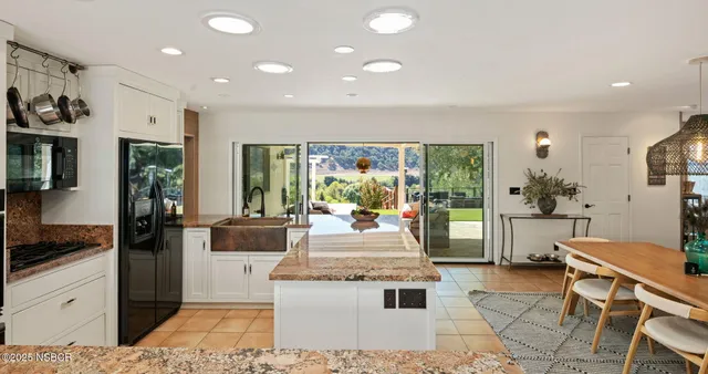 a kitchen with stainless steel appliances kitchen island granite countertop a refrigerator and stove