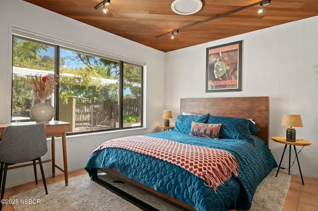 a bedroom with a bed and a large window