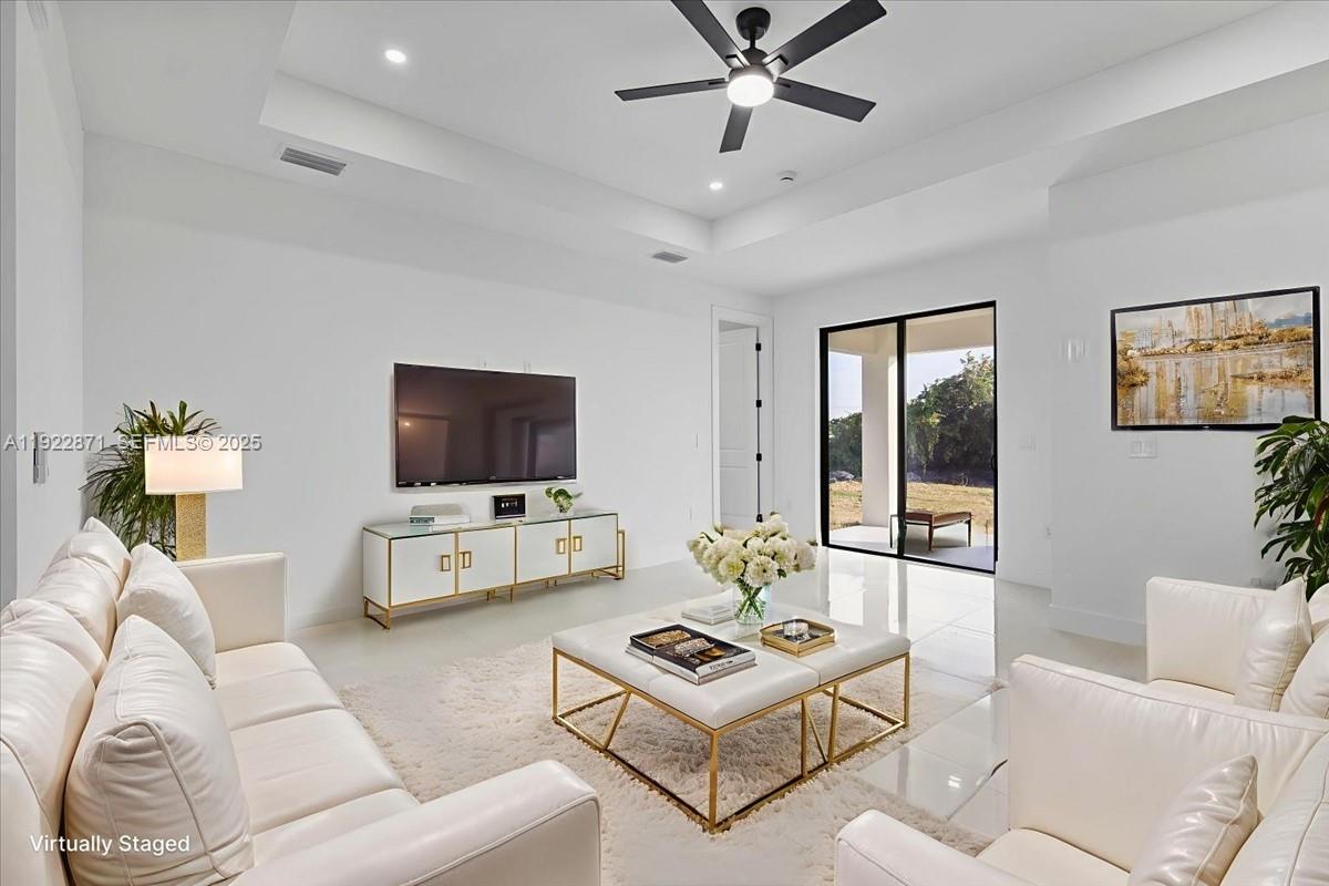 4207 28th Street Southwest Lehigh Acres, FL 33976 - Photo 2 of 39 a living room with furniture and a flat screen tv
