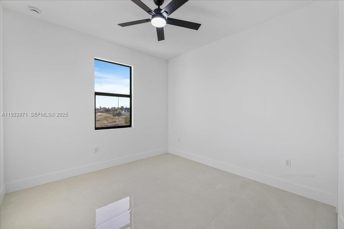 4207 28th Street Southwest Lehigh Acres, FL 33976 - Photo 25 of 39 an empty room with a window and a fan