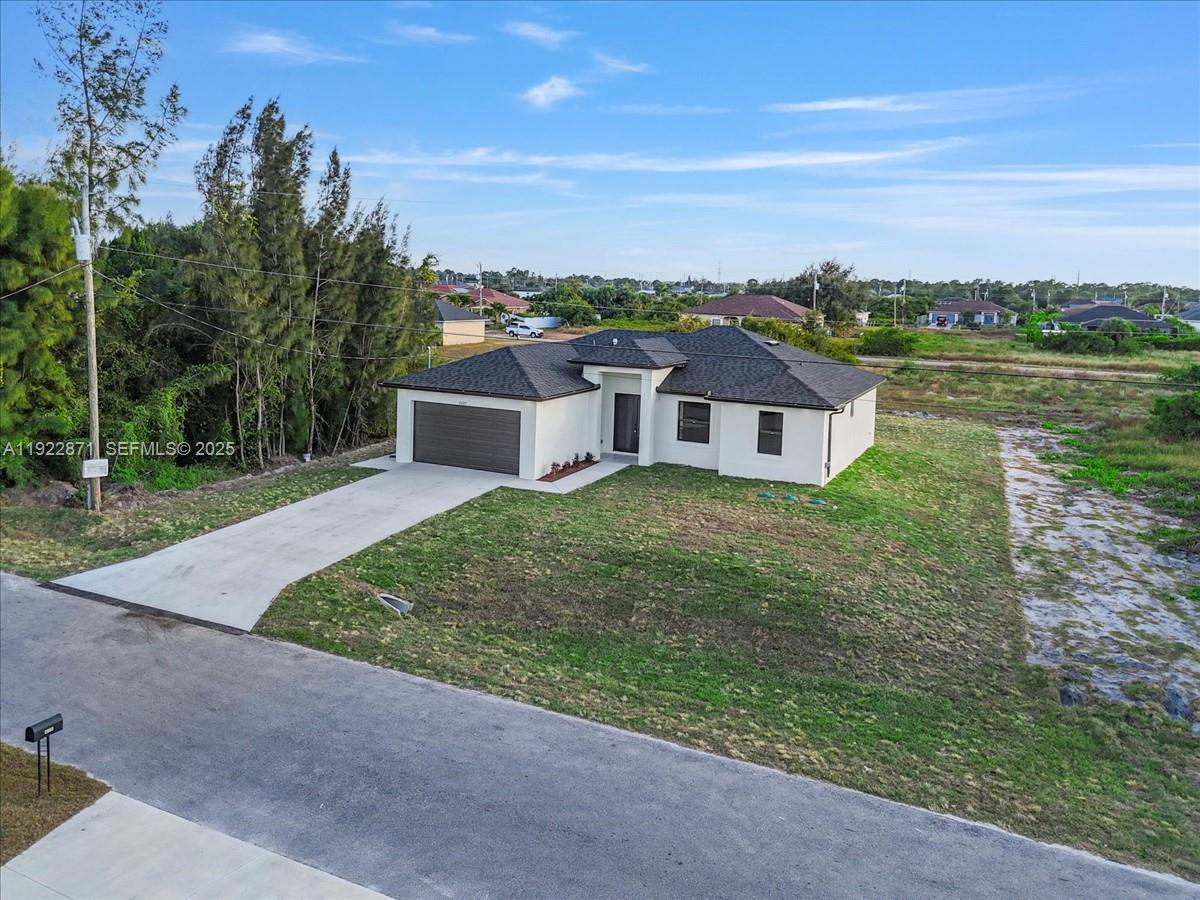 4207 28th Street Southwest Lehigh Acres, FL 33976 - Photo 33 of 39 an aerial view of residential house with outdoor space and trees