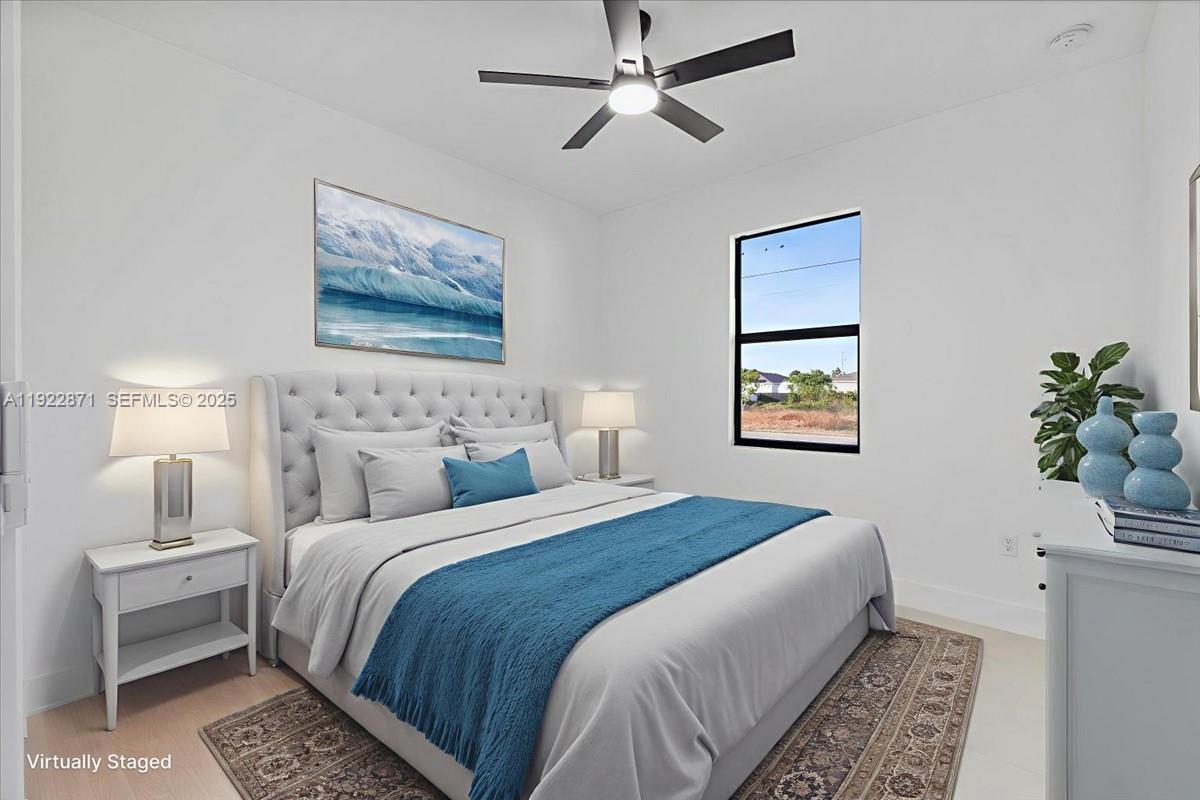 4207 28th Street Southwest Lehigh Acres, FL 33976 - Photo 6 of 39 a bedroom with bed and a chandelier