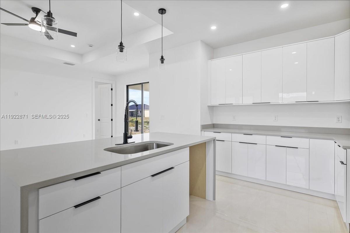 4207 28th Street Southwest Lehigh Acres, FL 33976 - Photo 10 of 39 a kitchen with a sink dishwasher and white cabinets