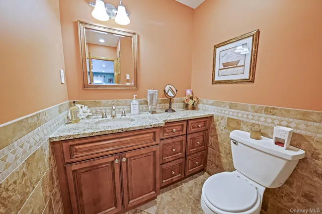 a bathroom with a granite countertop toilet sink and a mirror