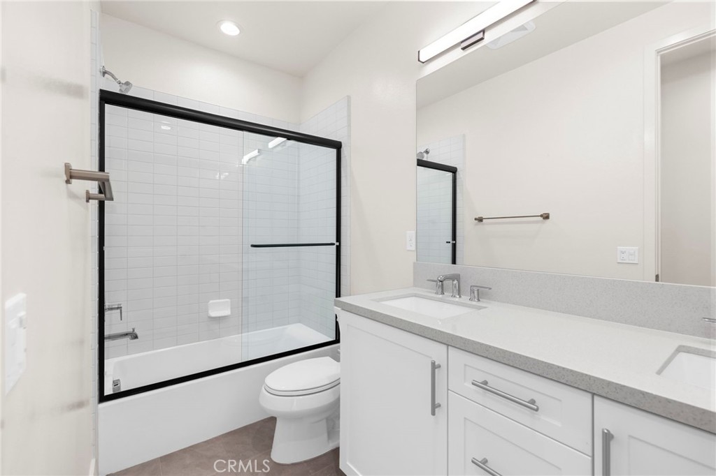 19011 Main Street, Unit 101 Huntington Beach, CA 92648 - Photo 26 of 36 a bathroom with a granite countertop sink mirror vanity and toilet