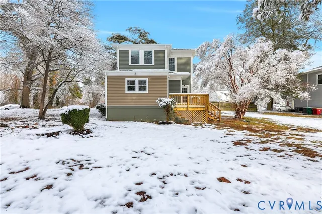 a view of a blue house with snow on the road