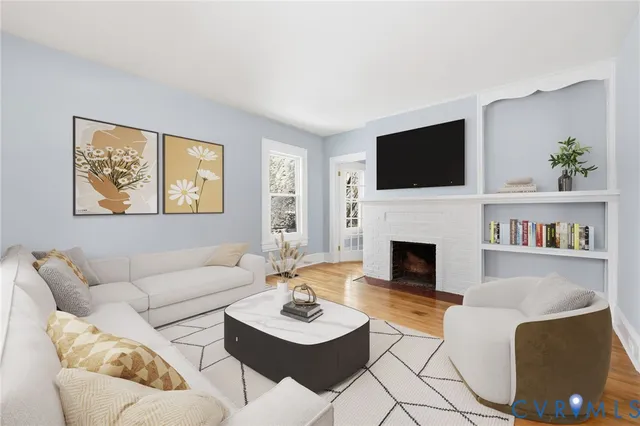 a living room with furniture a fireplace and a flat screen tv
