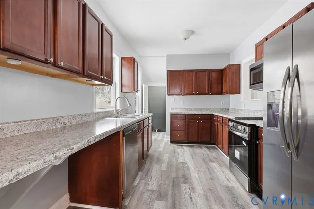 a kitchen with stainless steel appliances granite countertop a stove a sink and a refrigerator