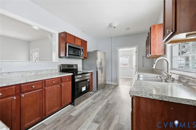 a kitchen with granite countertop a sink stove and refrigerator