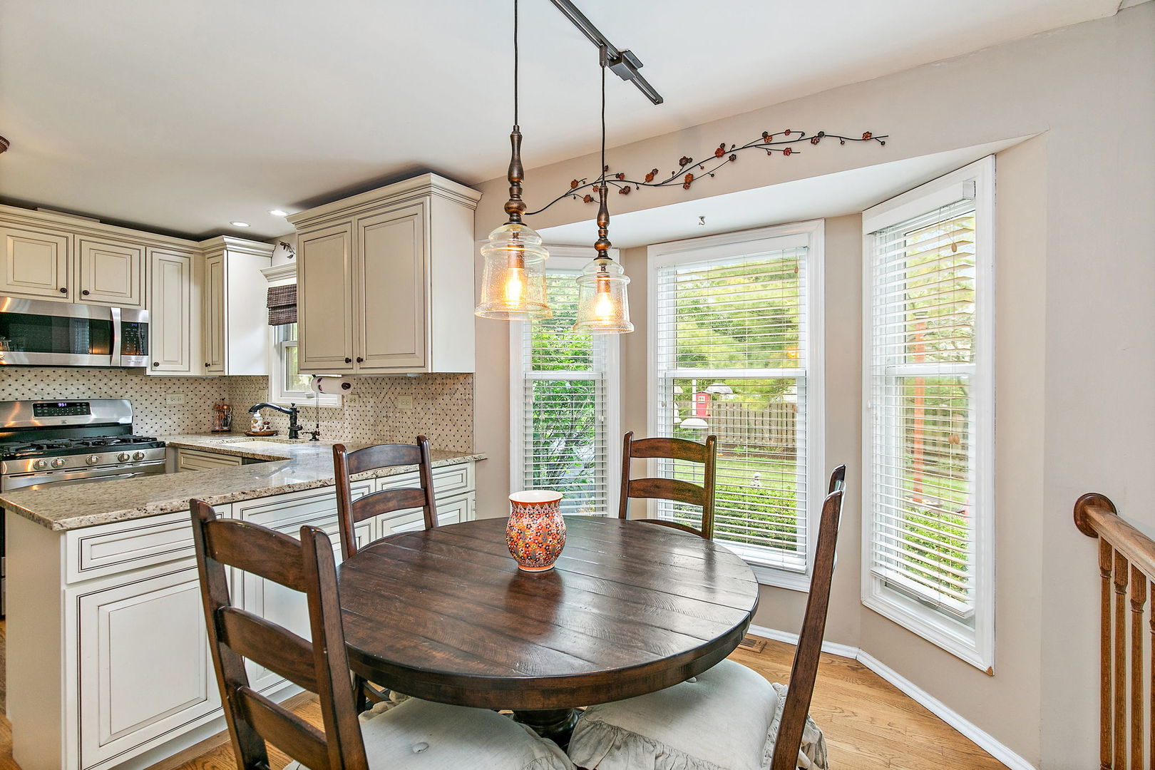 112 Thompson Boulevard Buffalo Grove, IL 60089 - Photo 12 of 34 a kitchen with stainless steel appliances granite countertop a stove a sink a microwave a dining table and chairs
