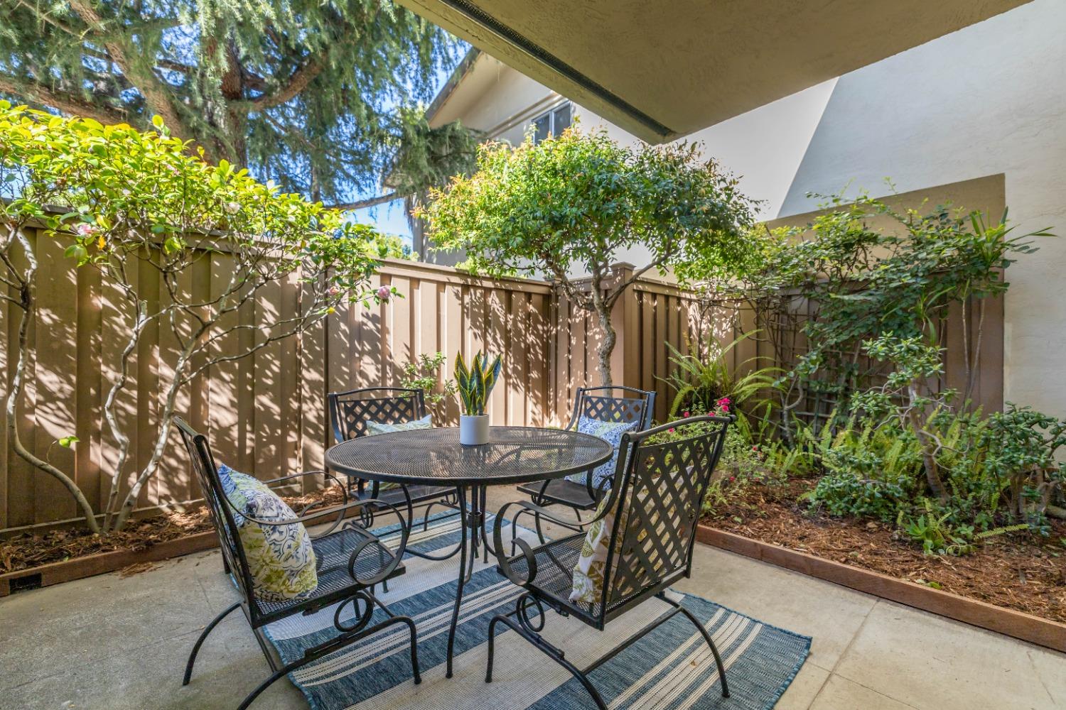 a view of a backyard with table and chairs and potted plants