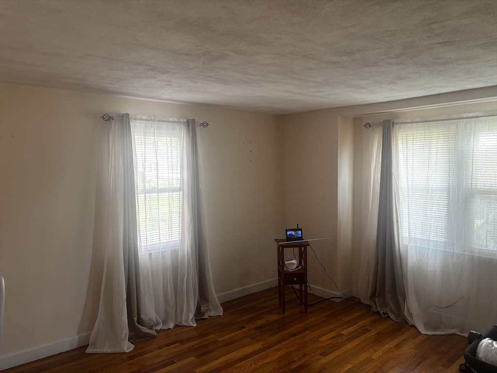 36 O Connell Street Springfield, MA 01104 - Photo 11 of 14 an empty room with wooden floor and windows