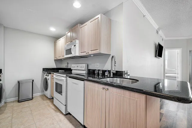 a kitchen with stainless steel appliances granite countertop a sink a stove and a refrigerator
