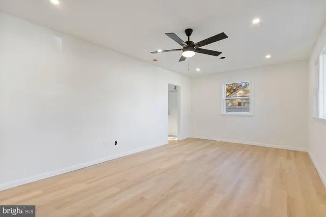 an empty room with a window and a fan