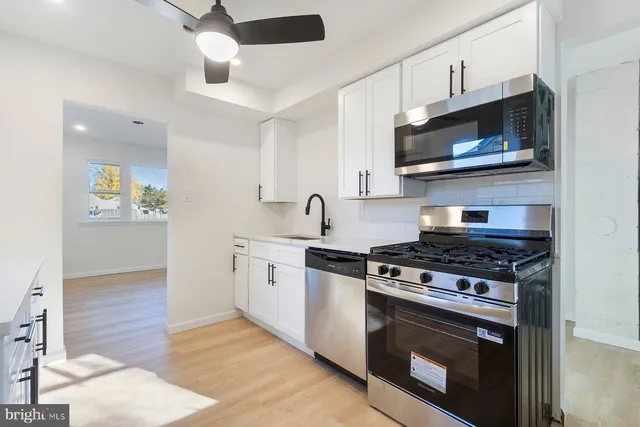 a kitchen with stainless steel appliances a sink a stove and microwave