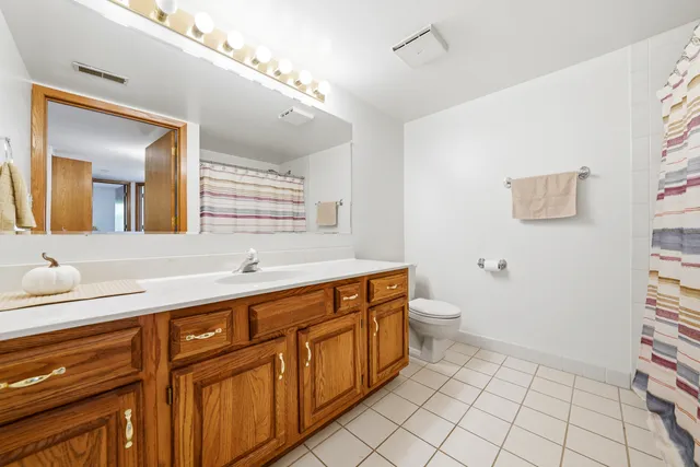 a spacious bathroom with a double vanity sink mirror and toilet