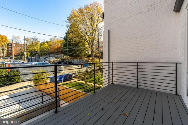 a view of a balcony with wooden floor and outdoor seating