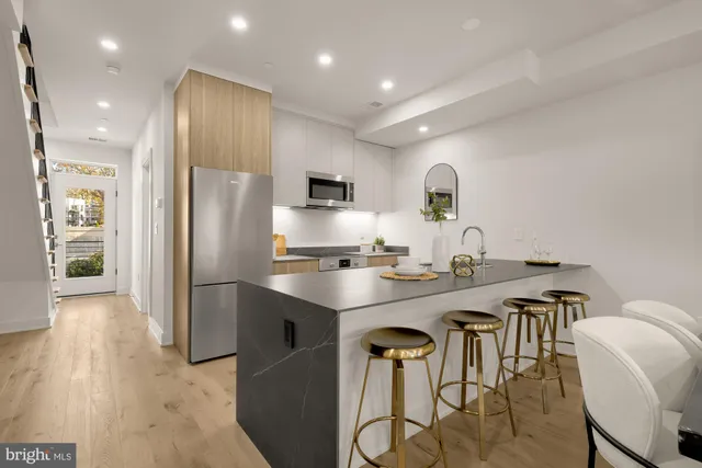 a kitchen with kitchen island a appliances dining table and chairs