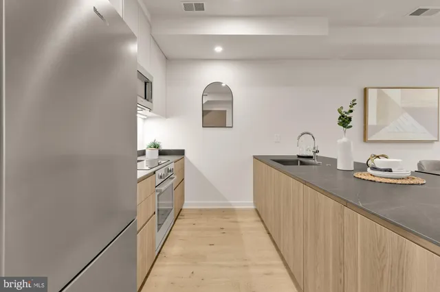 a kitchen with granite countertop a sink stove and cabinets