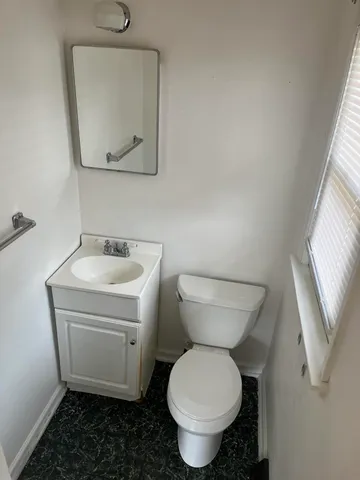 a bathroom with a toilet sink and mirror